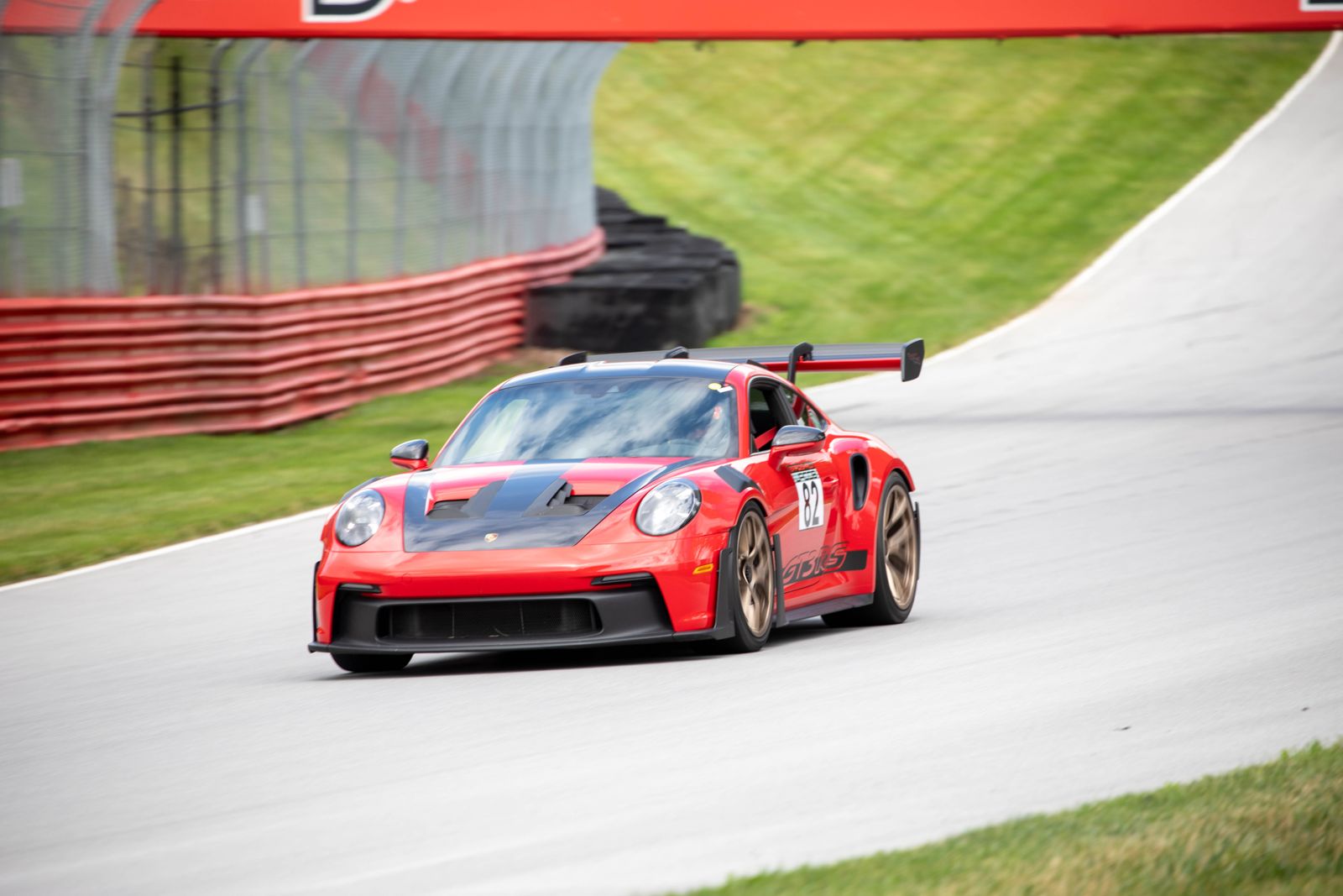 Bradshaw Autosport 992 GT3 RS #82 exiting the corner under the bridge at Mid-Ohio